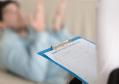 Psychologists office, female practitioner holding clipboard with
